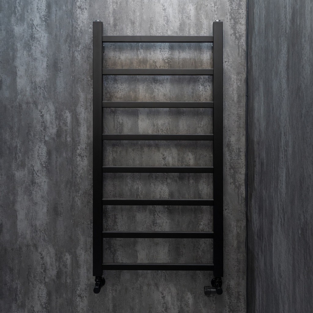 Black heated towel rail on slate wall tiles